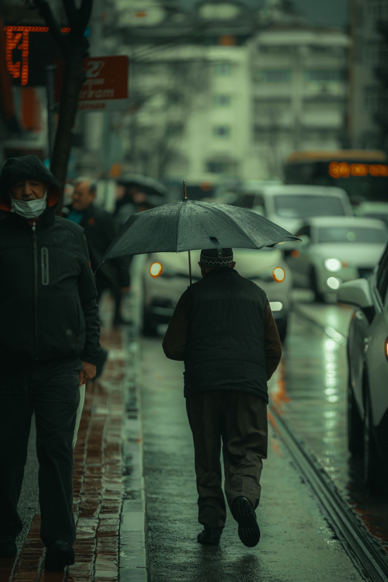 Man walking with umbrella on a rainy street - monsoon outfit guide for Indian men