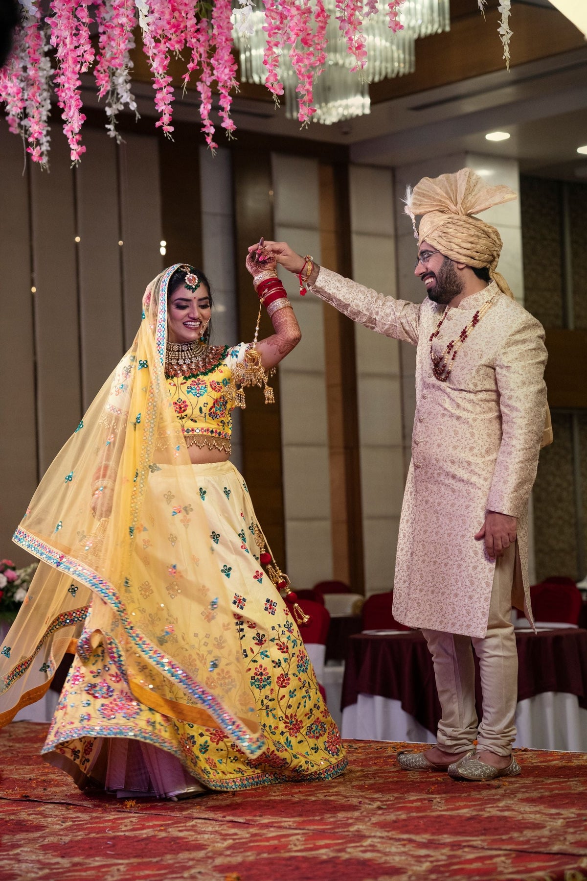 Couple dancing at a sangeet night under floral decor at an Indian wedding