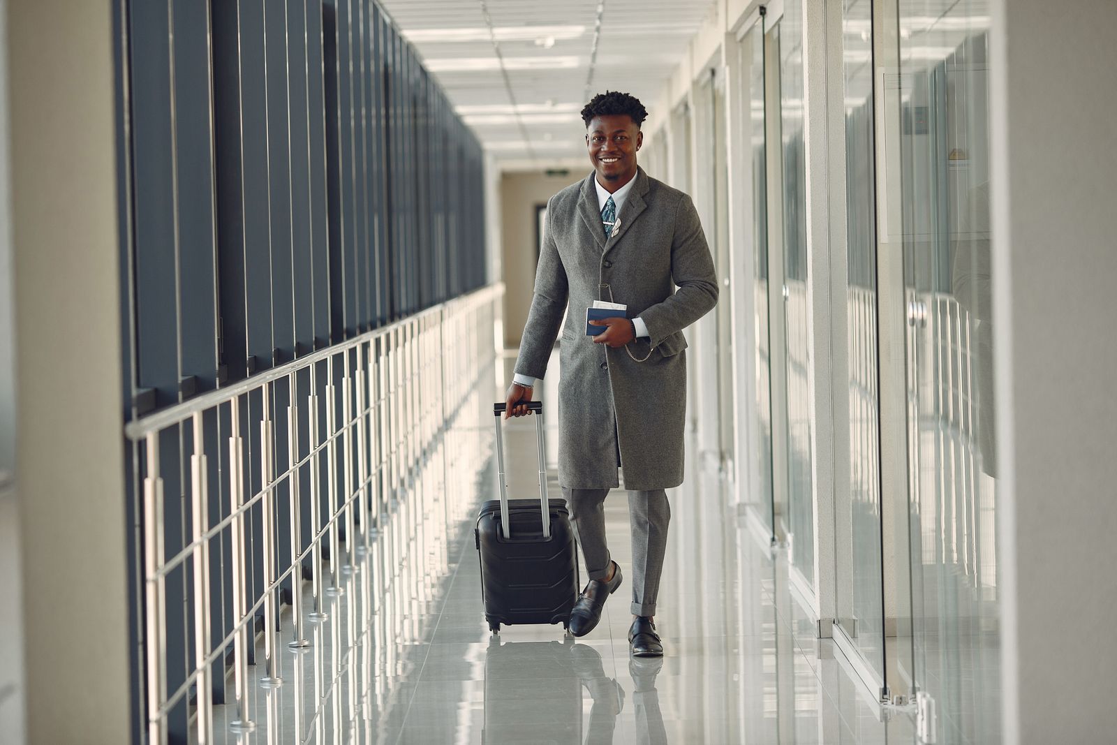 Stylish man with suitcase walking through airport corridor - travel co-ord outfit inspiration for Indian men