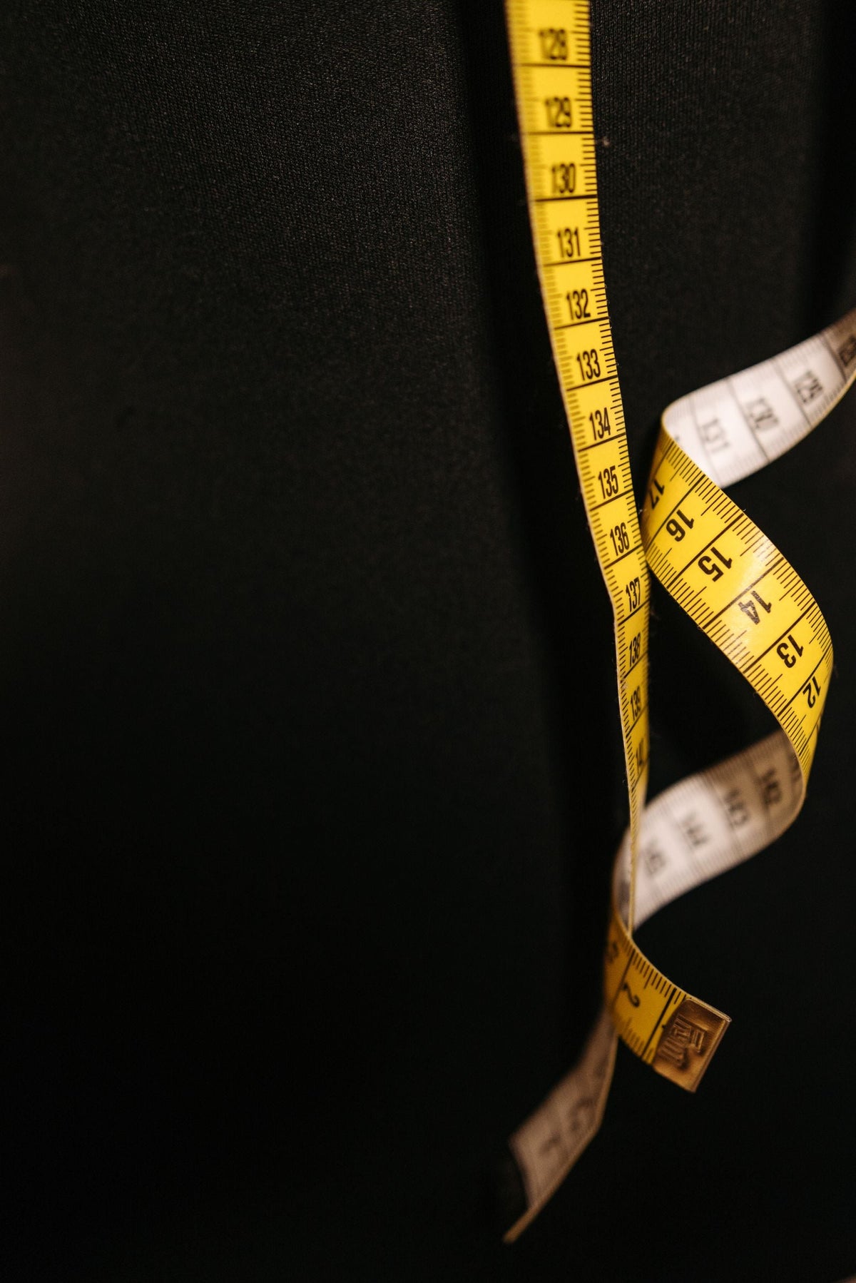 Tailor's measuring tape on dark fabric — getting co-ord set proportions right for shorter men in India