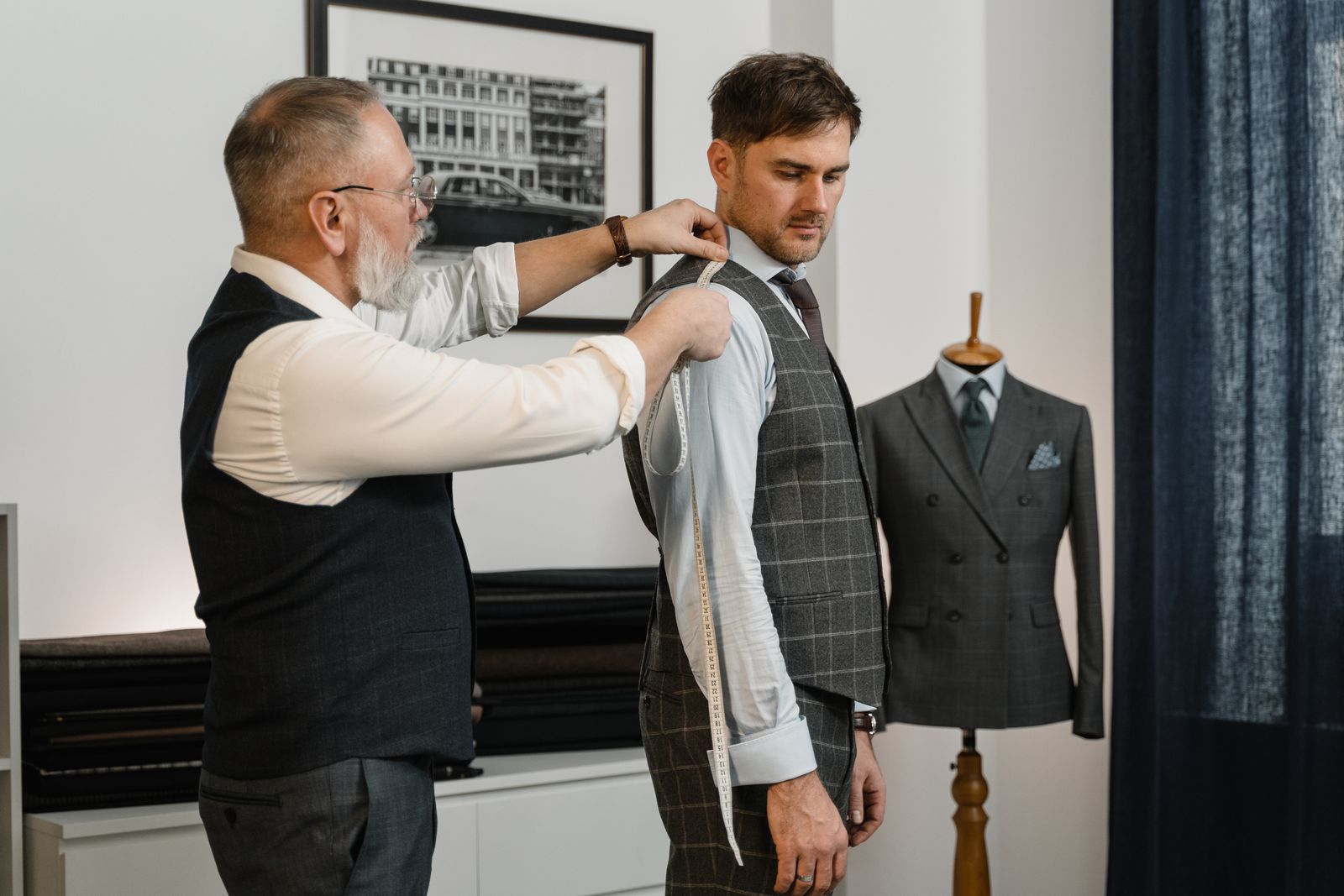 Tailor measuring a man's chest with a tape measure for the right co-ord set size