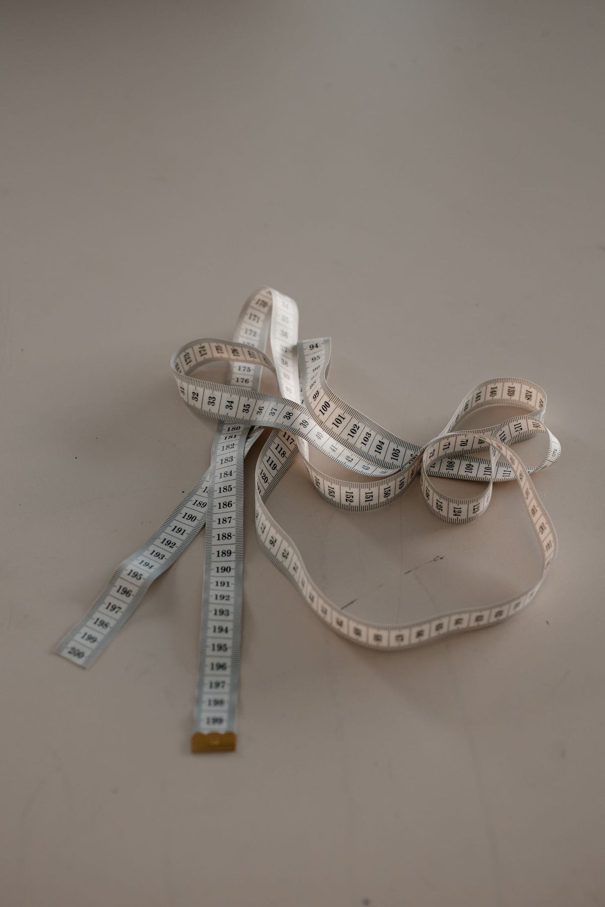 White measuring tape coiled on a neutral background — measure chest and waist before buying a plus size co-ord set in India