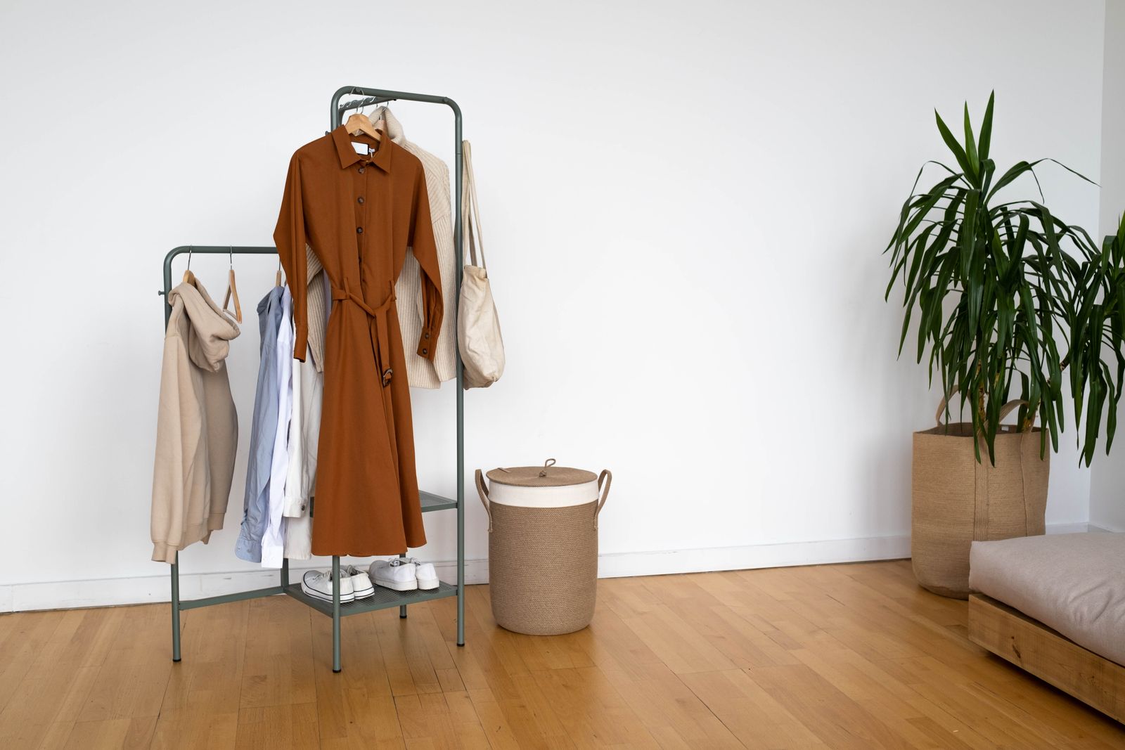 Minimal capsule wardrobe for men — neutral shirts and trousers on a clothes rack in a modern interior