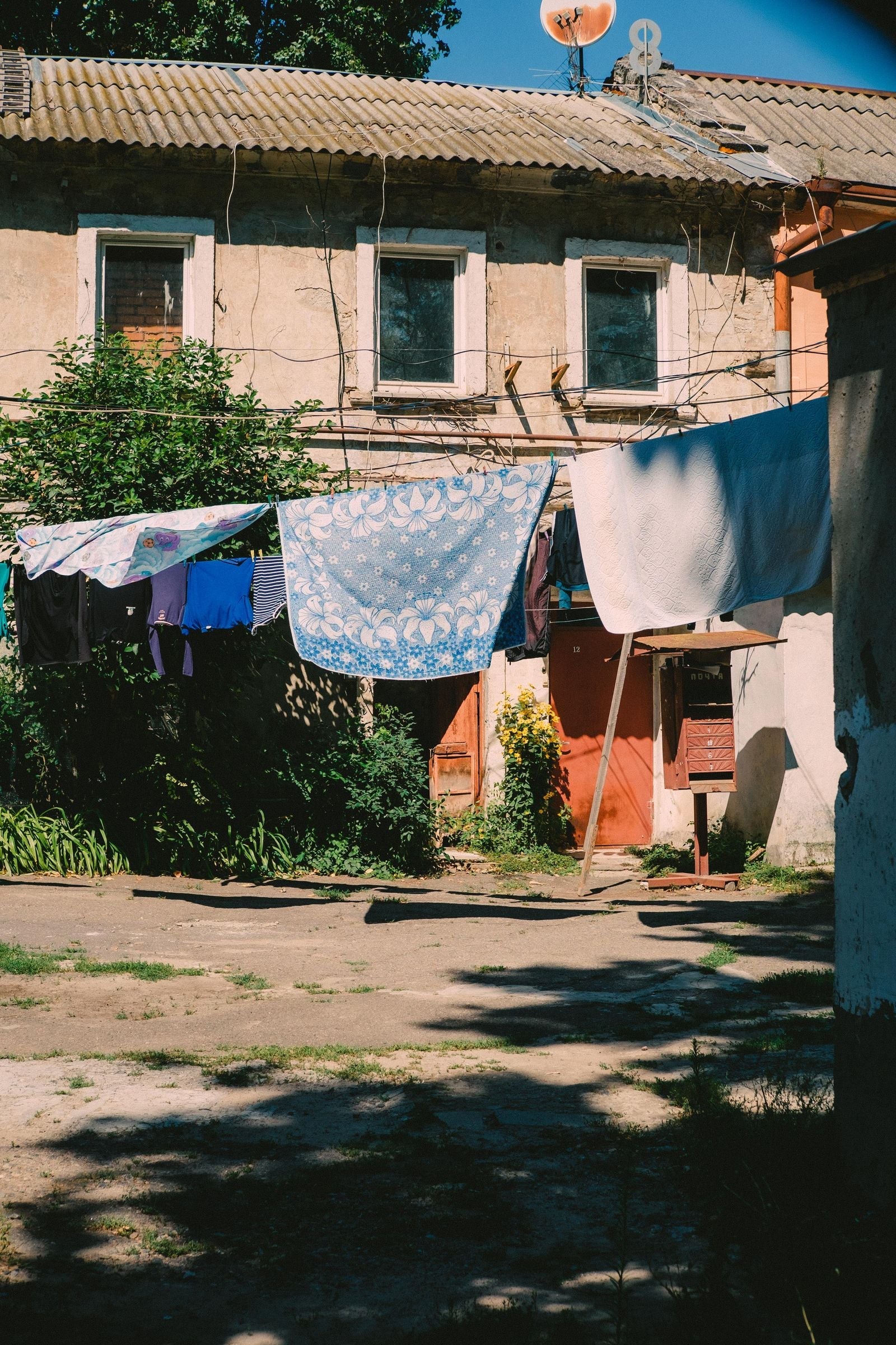 Sun drying laundry on a clothesline - how to wash and care for linen clothes